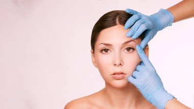 Estetik cilt konsültasyonu. Hasta ve doktor eldivenleri. Kozmetoloji tedavisi.