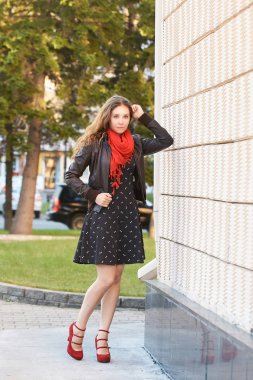 Duvarın yanında poz veren genç bir kız. Yaz zamanı..