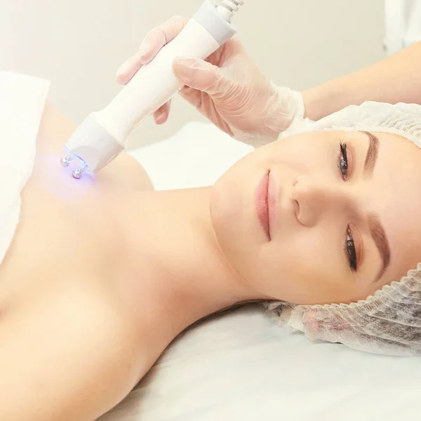 Facial micro current cosmetology procedure. Beauty technology treatment. Woman face therapy.