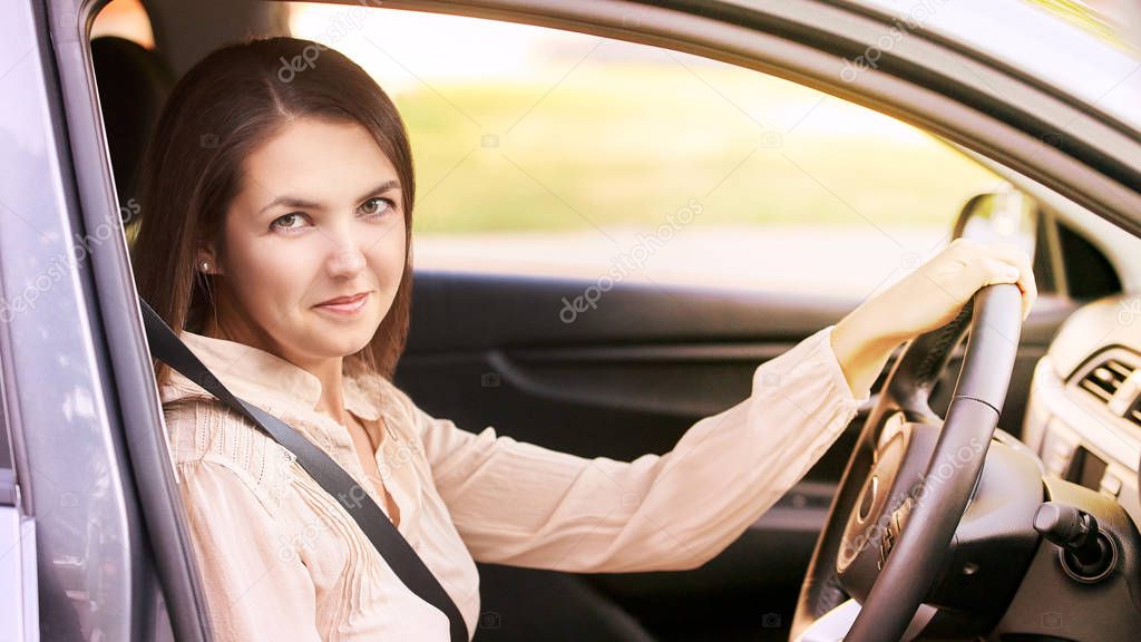 Young woman in car. Ride instruction. Automobile loan.