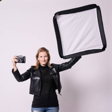 Kız fotoğrafçı. Softbox. Siyah elbiseli. Beyaz arka plan.