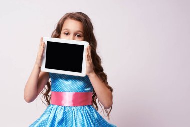 Küçük kız. Kabarık elbise. Modern tablet.