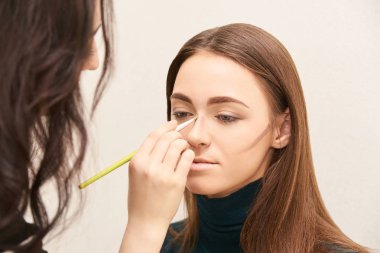 Profesyonel makyöz yüz maskara uygulayın. Kadın güzellik modeli. Doğa çıplak bak. Kontur Vakfı.