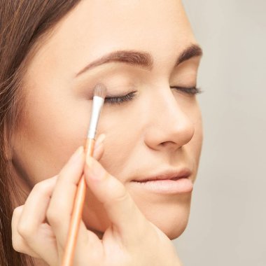 Profesyonel makyöz yüz maskara uygulayın. Kadın güzellik modeli. Doğa çıplak bak. Kontur Vakfı.