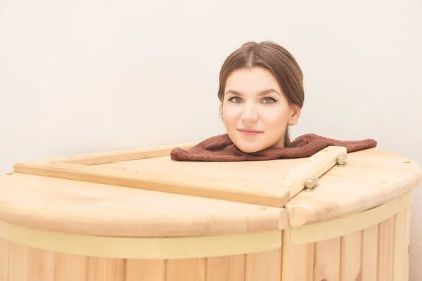 Barrel cedar. Wellness spa sauna. Aromatherapy treatment. Young beauty woman. Girl face.