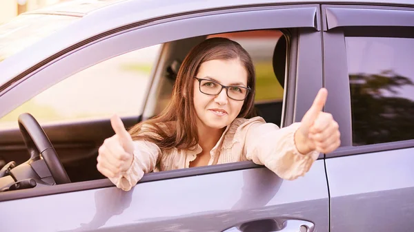 Young woman in car. Ride instruction. Automobile loan.