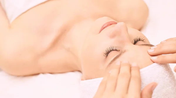 Menina Beleza Recebendo Massagem Facial Salão Toalha Branca Mãos Pessoas — Fotografia de Stock