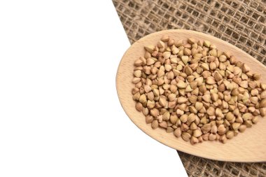 Buğday taneleri. Nötr arka plan. Sağlıklı gıda. Tahta kaşık.