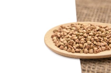 Buğday taneleri. Nötr arka plan. Sağlıklı gıda. Tahta kaşık.