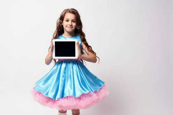 现代技术 漂亮的小女孩郁郁葱葱的蓝色连衣裙 — 图库照片