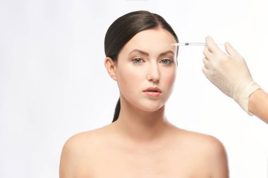 Yüz iğnesi. Genç kadın kozmetoloji prosedürü. Doktor eldivenleri.