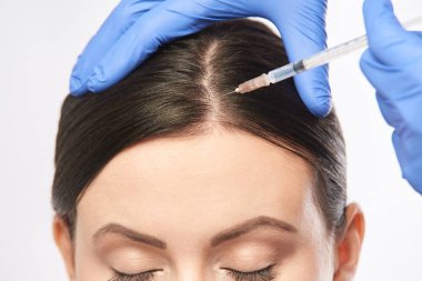 Yüz iğnesi. Genç kadın kozmetoloji prosedürü. Doktor eldivenleri.