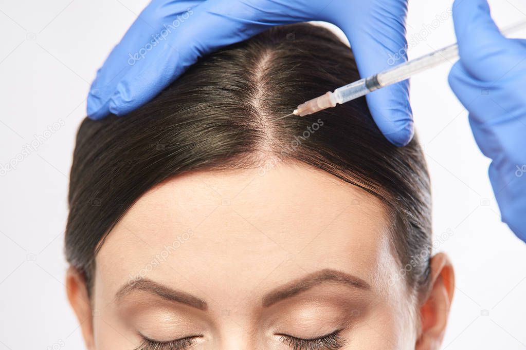 Face needle injection. Young woman cosmetology procedure. Doctor gloves.