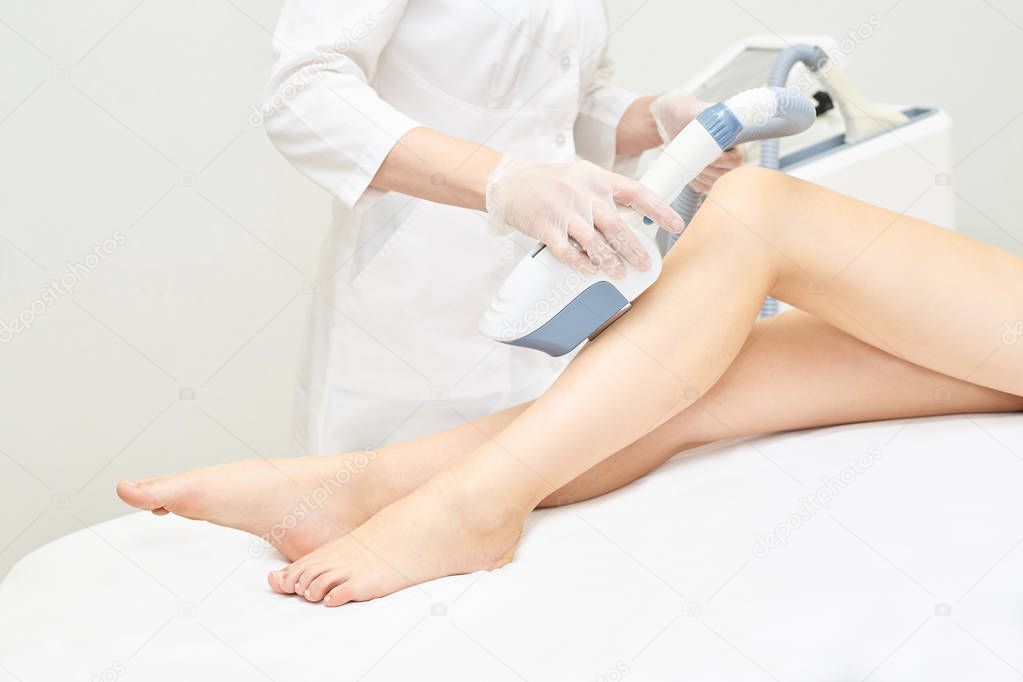 Laser ipl device in doctor hand. Woman body hair removal. Perfect epilator. Cosmetology leg technology.