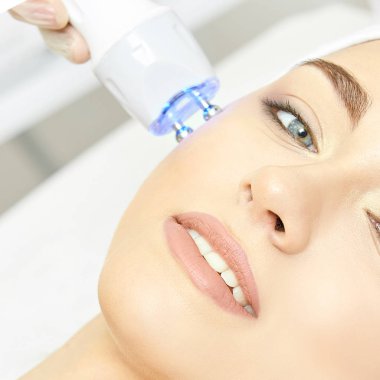 Kızılötesi ışık tedavisi. Kozmetik baş yordamı. Güzellik kadını yüz. Kozmetik salonu aygıt. Yüz cilt gençleştirme.