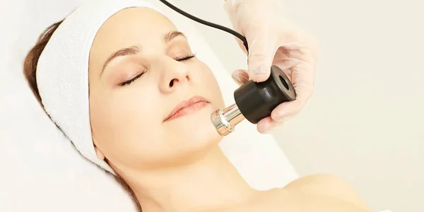 Electroporation facial rejuvenation. Cosmetology face treatment. Salon cosmetic hardware. Medical woman equipment. Beauty girl.