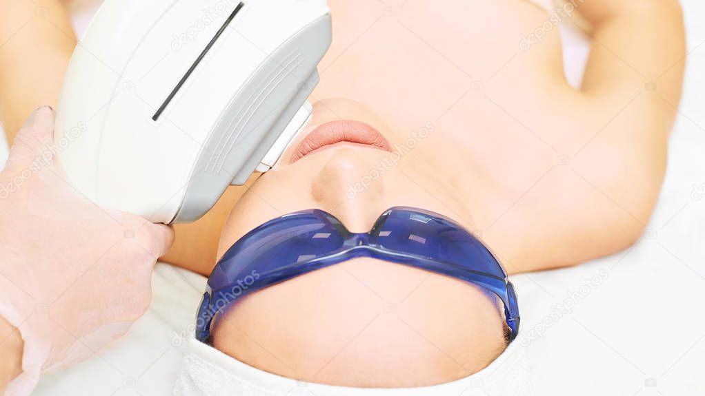 Laser facial hair removal. Cosmetology ipl device. Woman body in clinic. Medical beauty girl. Acne salon treatment tool.