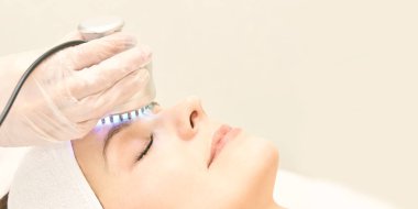 Kızılötesi ışık tedavisi. Kozmetik baş yordamı. Güzellik kadını yüz. Kozmetik salonu aygıt. Yüz cilt gençleştirme