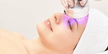 Kızılötesi ışık tedavisi. Kozmetik baş yordamı. Güzellik kadını yüz. Kozmetik salonu aygıt. Yüz cilt gençleştirme