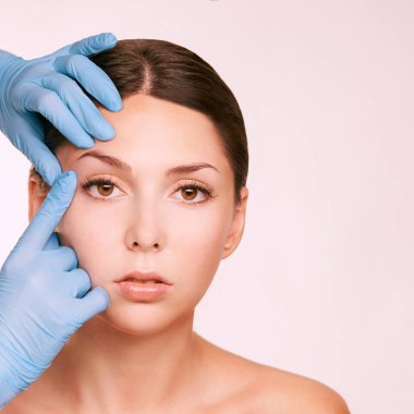 Kadın derma tedavi gençleştirmek. Eldivenli doktor kadın yüzüne dokunur. Kozmetoloji güzel portre. Yüz enjeksiyonu hastası
