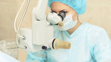 Güzel doktor kadın portresi. Oftalmoloji lazer mikroskop operasyonu. Klinik odası. Hasta göz tedavisi. Miyopi ve katarakt giderme