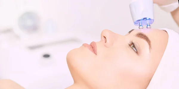 Microstroom lichte esthetiek procedure. Het gezicht van het meisje van schoonheid. Cosmetologie machine. Handen van de arts. Twee micro ballen. Rimpel vermindering — Stockfoto