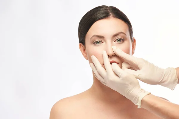 Kadın derma tedavi gençleştirmek. Eldivenli doktor kadın yüzüne dokunur. Kozmetoloji güzel portre. Yüz enjeksiyonu hastası