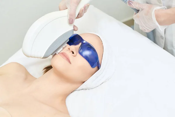 Depilación facial con láser. Dispositivo ipl de cosmetología. Cuerpo de mujer en la clínica. Chica de belleza médica. Herramienta de tratamiento de salón de acné — Foto de Stock