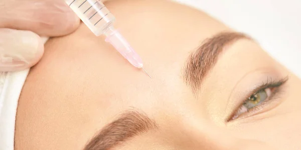 Chirurgie du front. Remplisseur anti rides. Injection de cosmétologie. Rajeunissement de la peau du visage. Médecin injectant de l'acide collagène — Photo