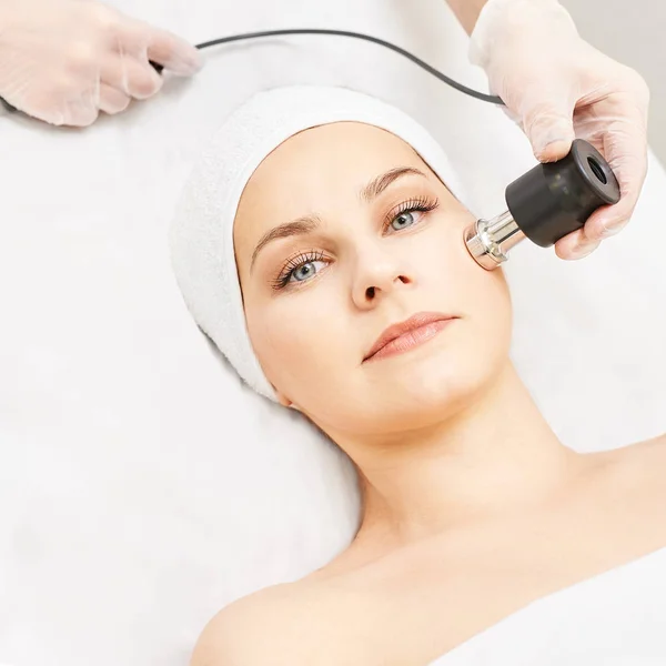 Elettroporazione donna trattamento viso. Terapia di ringiovanimento facciale. Cosmetologia attrezzature per la cura della pelle. Sollevamento RF. Dispositivo di massaggio — Foto Stock