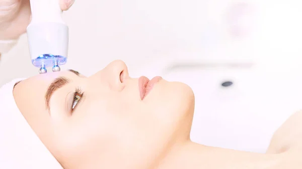 Microstroom lichte esthetiek procedure. Het gezicht van het meisje van schoonheid. Cosmetologie machine. Handen van de arts. Twee micro ballen. Rimpel vermindering — Stockfoto