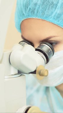 Güzel doktor kadın portresi. Oftalmoloji lazer mikroskop operasyonu. Klinik odası. Hasta göz tedavisi. Miyopi ve katarakt giderme