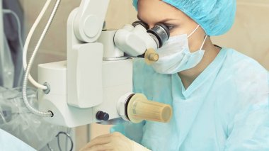 Güzel doktor kadın portresi. Oftalmoloji lazer mikroskop operasyonu. Klinik odası. Hasta göz tedavisi. Miyopi ve katarakt giderme