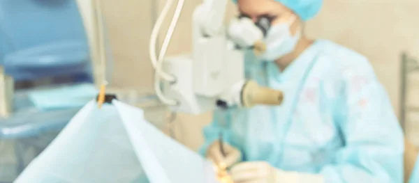 Operação de microscópio a laser oftalmológico. Sala da clínica com médico e parente. Contexto azul. Desfoco, foco seletivo — Fotografia de Stock