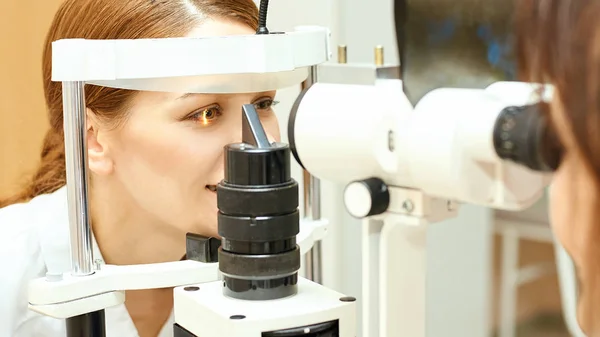 眼科医の検査視力回復乱視チェックの概念。眼科診断装置。クリニックで美少女の肖像画 — ストック写真