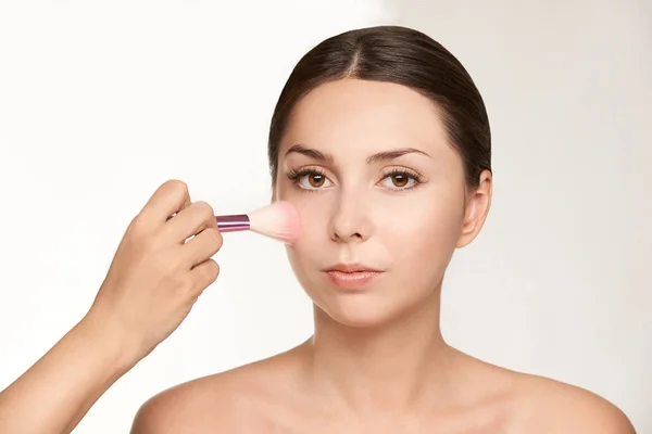 Woman make makeup. Face cosmetic. Skin care. Facial hightlighter. Mascara