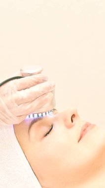 Kızılötesi ışık tedavisi. Kozmetik baş yordamı. Güzellik kadını yüz. Kozmetik salonu aygıt. Yüz cilt gençleştirme