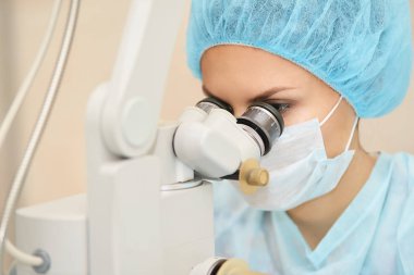 Güzel doktor kadın portresi. Oftalmoloji lazer mikroskop operasyonu. Klinik odası. Hasta göz tedavisi. Miyopi ve katarakt giderme