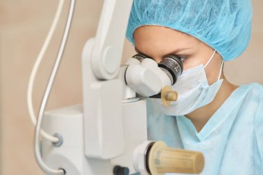 Güzel doktor kadın portresi. Oftalmoloji lazer mikroskop operasyonu. Klinik odası. Hasta göz tedavisi. Miyopi ve katarakt giderme