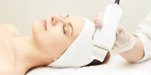 Ultrasone huid apparatuur. Vrouw gezicht cosmetologie behandeling. Meisje kliniek gezicht procedure. Anti acne chirurgie schoonmaken — Stockfoto