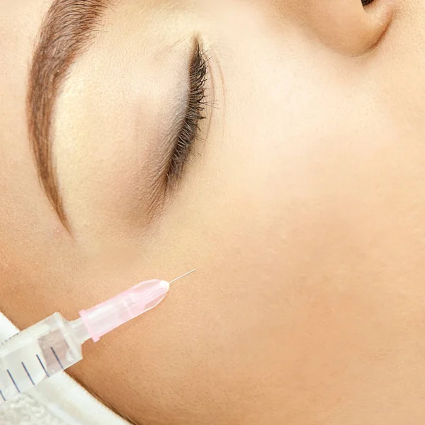 Vrouw gezicht cosmetologie behandeling. Biorevitalization huid-therapie. Dokter invoegen vuller. Meisje kliniek gezicht Mesotherapie. Injecterend drugsgebruik in medische salon — Stockfoto