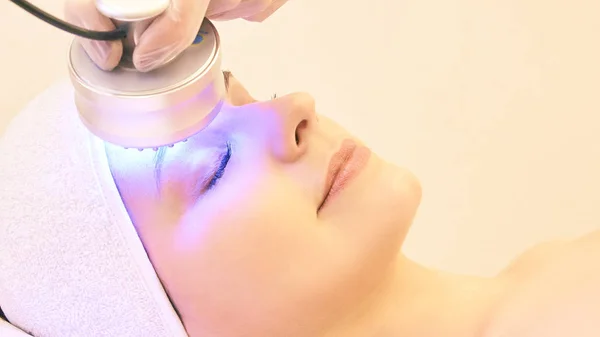 Infrarood Lichttherapie. Cosmetologie hoofd procedure. De gezicht van de vrouw van de schoonheid. Cosmeticastudio apparaat. Verjonging van de gezichtshuid — Stockfoto