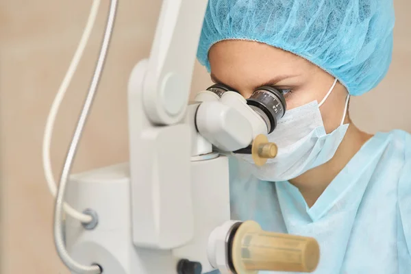 Bonito retrato de doctora. Operación de microscopio láser oftalmológico. Sala de la clínica. Tratamiento ocular del paciente. Miopía y eliminación de cataratas —  Fotos de Stock