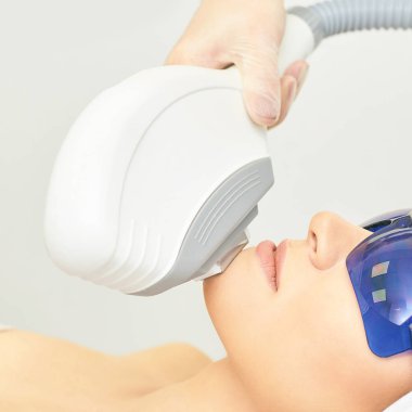 Anti akne kaldırma prosedürü. Kozmetoloji cihazı. Kadın yüz sıkılaştırma kliniği. Güzel kız ve doktor el