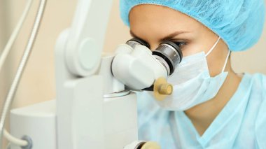 Güzel doktor kadın portresi. Oftalmoloji lazer mikroskop operasyonu. Klinik odası. Hasta göz tedavisi. Miyopi ve katarakt giderme