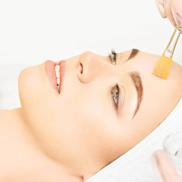 Gezichtsborstel schil retinol behandeling. Schoonheidsvrouw peeling procedure. Cosmetologie jonge meisje therapie.Hyaluronzuur — Stockfoto