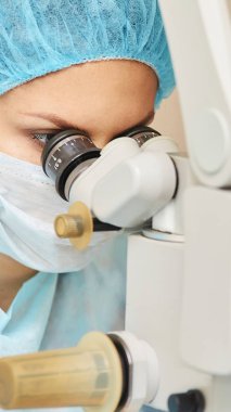 Güzel doktor kadın portresi. Oftalmoloji lazer mikroskop operasyonu. Klinik odası. Hasta göz tedavisi. Miyopi ve katarakt giderme