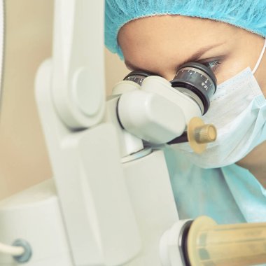 Güzel doktor kadın portresi. Oftalmoloji lazer mikroskop operasyonu. Klinik odası. Hasta göz tedavisi. Miyopi ve katarakt giderme