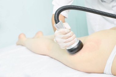 Süpürge masaj aleti. Selülit önleyici vücut düzeltme tedavisi. Zayıflama aleti. Tıp salonundaki kadın ve doktor.