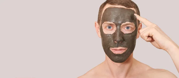 Czarna maska gliny na twarzy faceta — Zdjęcie stockowe